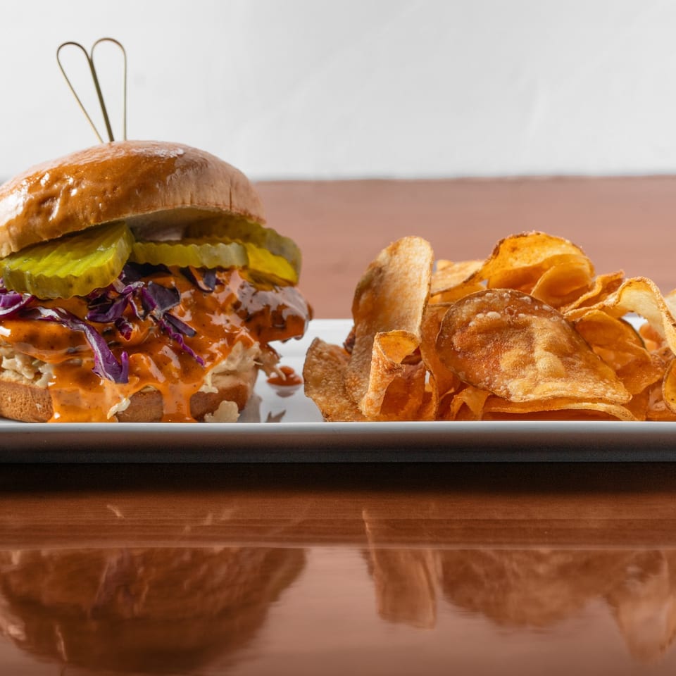Nashville hot chicken sandwich with slaw and pickles, served with house chips.